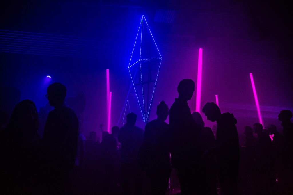 Silhouettes of fans under blue neon lights